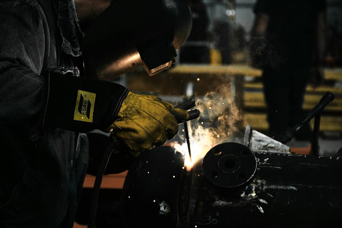 Close-up of heat resistant chemical gloves handling hot glassware with chemical residue